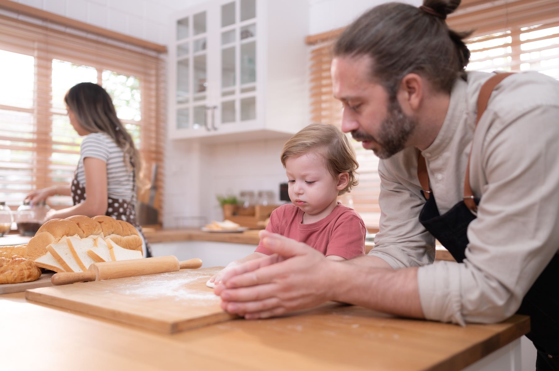 Father baking bread with his young son in the kitchen